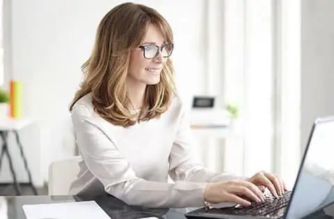 Frau sitzt vor dem Laptop